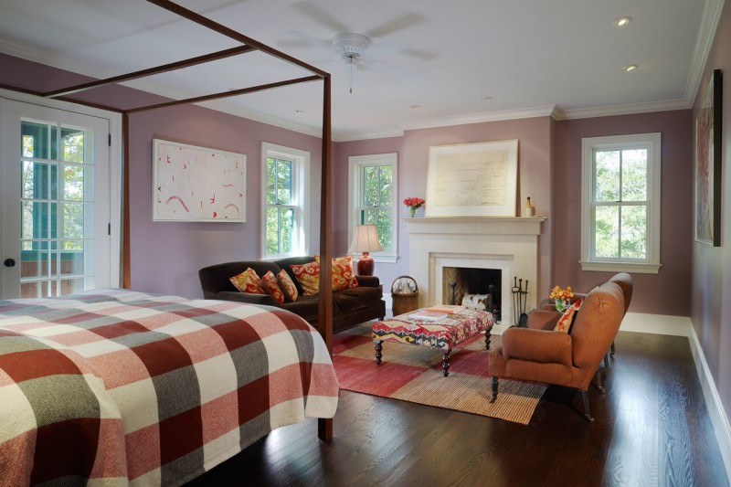 A bedroom with fireplace and mauve walls