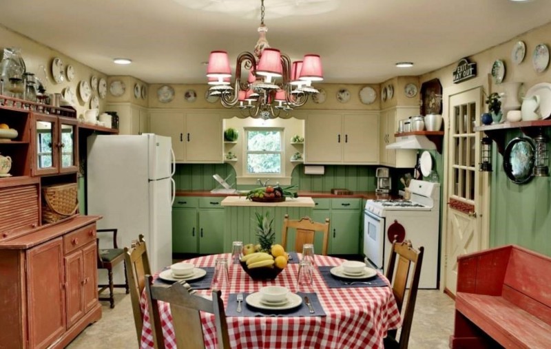 Connie\'s kitchen with green lower cabinets and round kitchen table