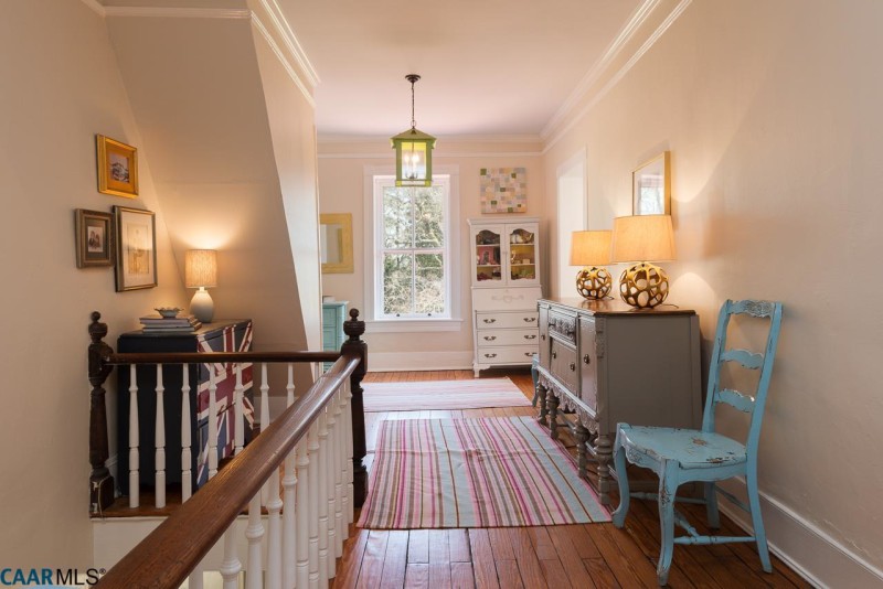 Upstairs landing with striped rug and dresser