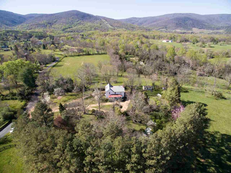 aerial view of white farmhouse and surrounding acreage