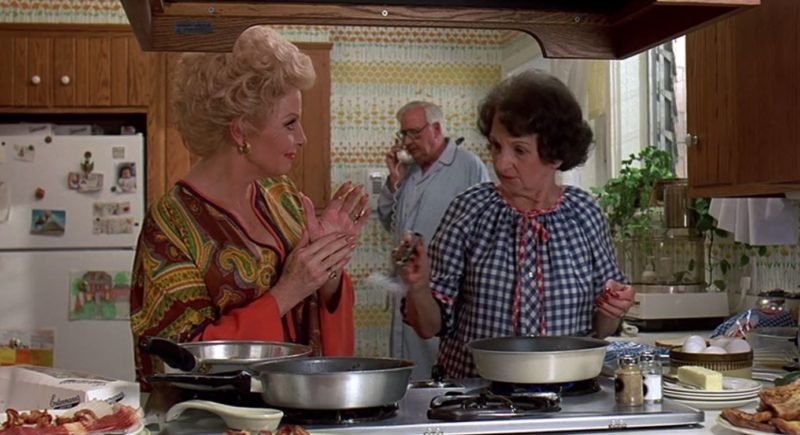 Characters cooking in the 1980s kitchen from Sixteen Candles