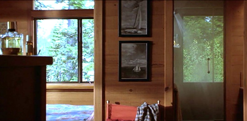 Closeup of framed photographs on cabin wall and door to bathroom