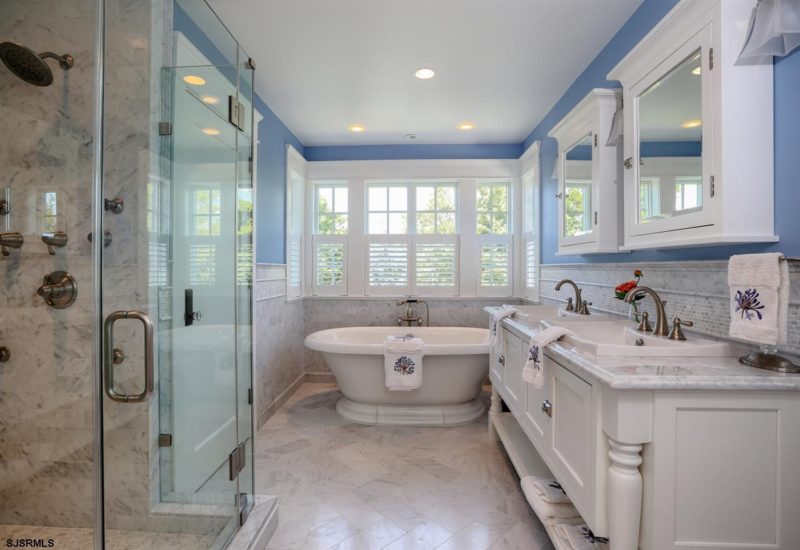 Owner\'s bathroom with freestanding tub, shower, and blue walls