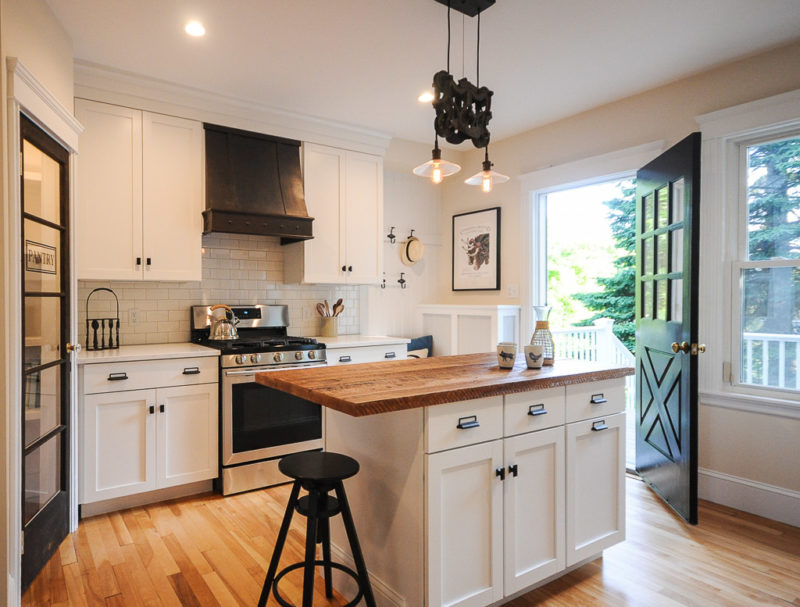 A kitchen with an island in the middle of a hard wood floor