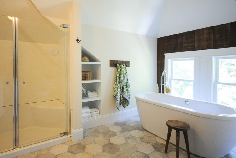 Freestanding tub and built-in shelves in bathroom