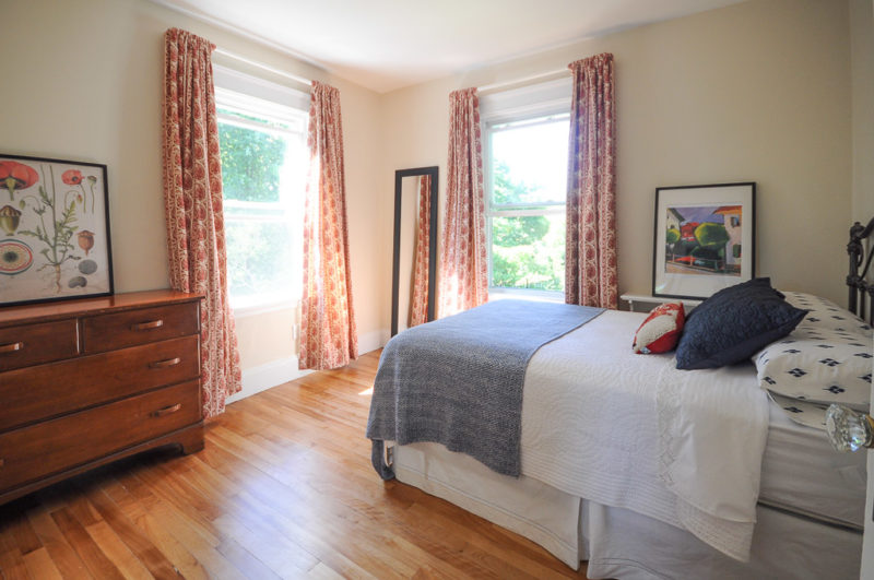 A bedroom with a wood floor