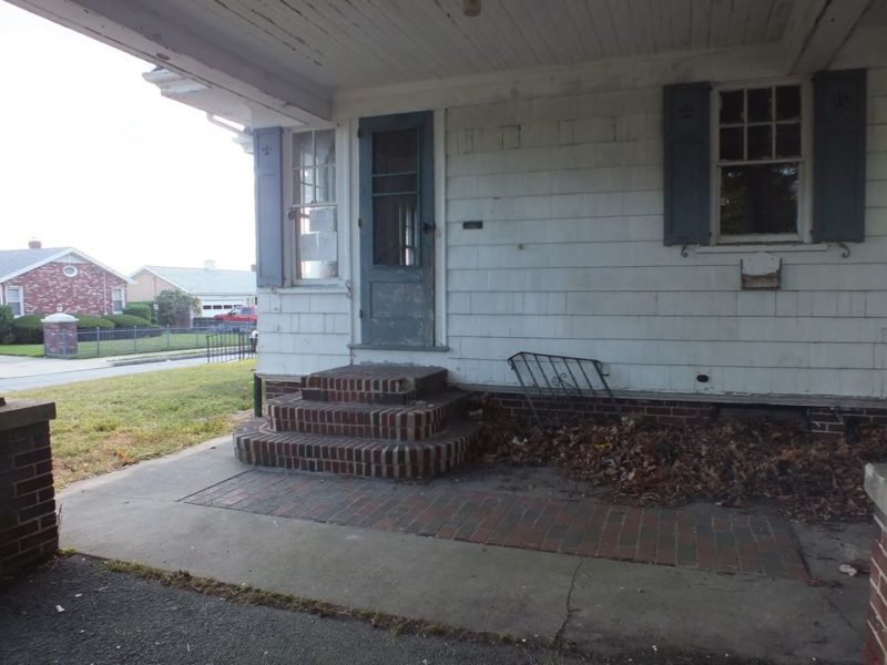 Exterior view of side door with brick steps before remodel