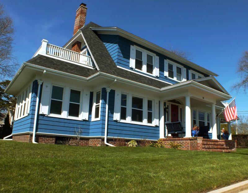 Front exterior of house after remodel with new blue siding and white shutters