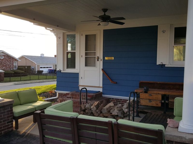 Exterior view of side door with brick steps and new blue siding