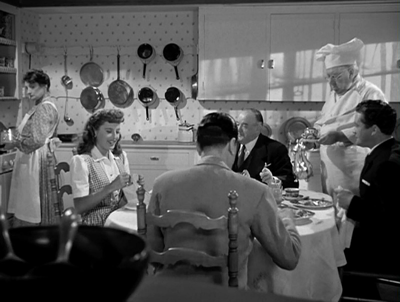 Characters sit around the kitchen table 