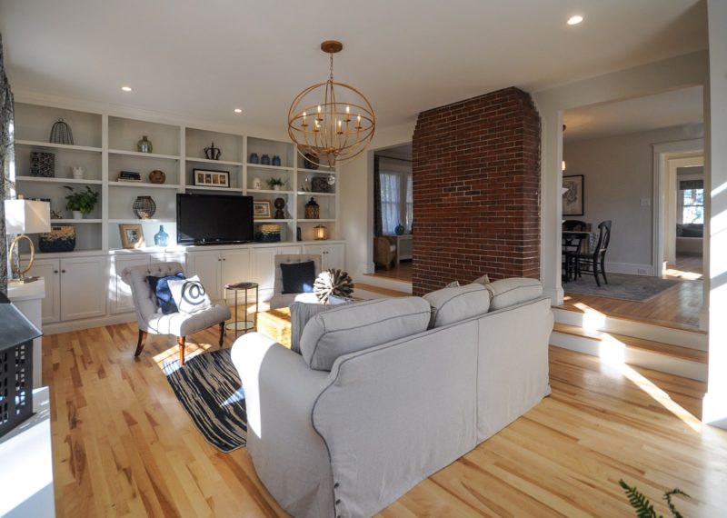 A living room with bookshelves and brick wall