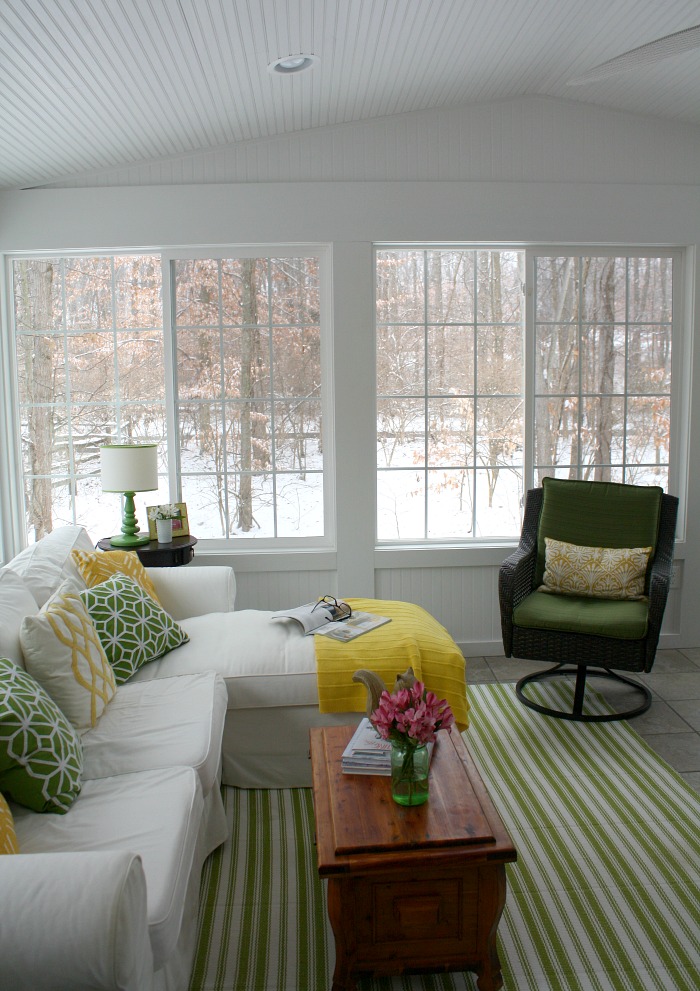 My sunroom with white Ektorp sofa and green chair on a snowy winter