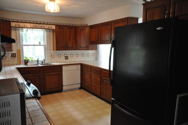 Kitchen with black refrigerator before remodel