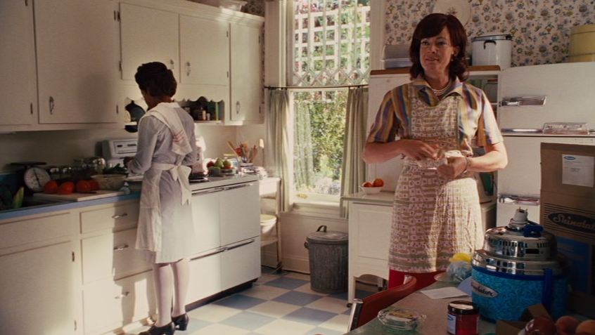 A person standing in a kitchen preparing food, with Allison Janney