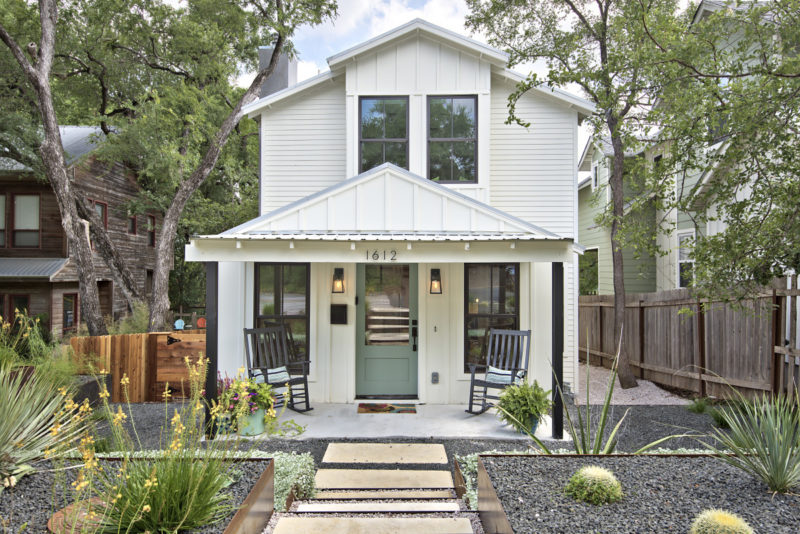 Front exterior of modern farmhouse in Austin with front porch and teal door