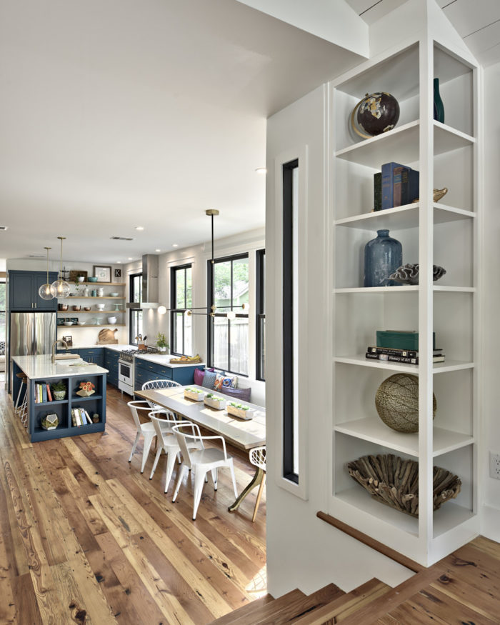 Closeup of built-in shelves in entry way with kitchen behind it