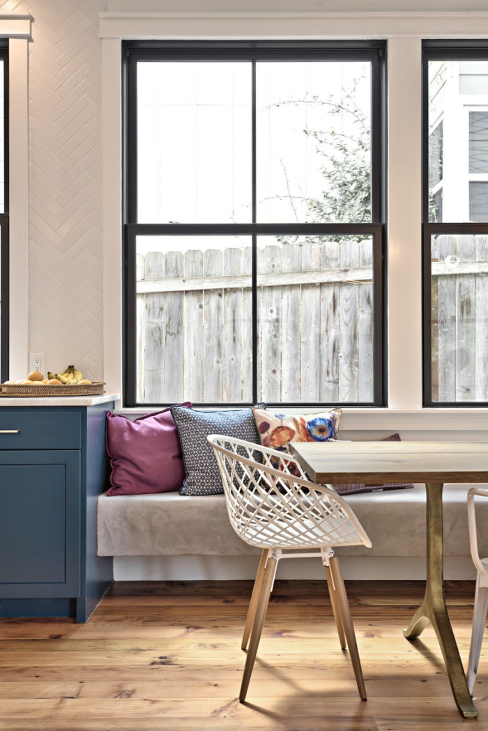 Banquette seating in kitchen in front of large windows