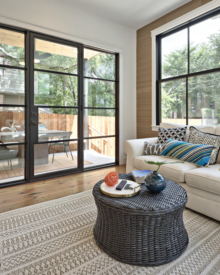 Sunroom with black metal doors leading to patio outside