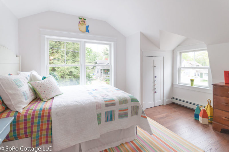 An upstairs bedroom with hardwood floor and rug