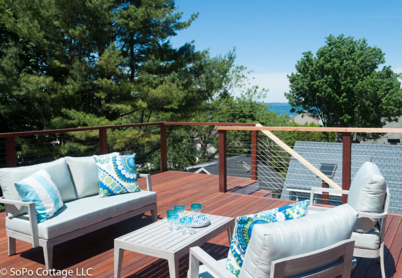 Upper deck behind house with view of the water