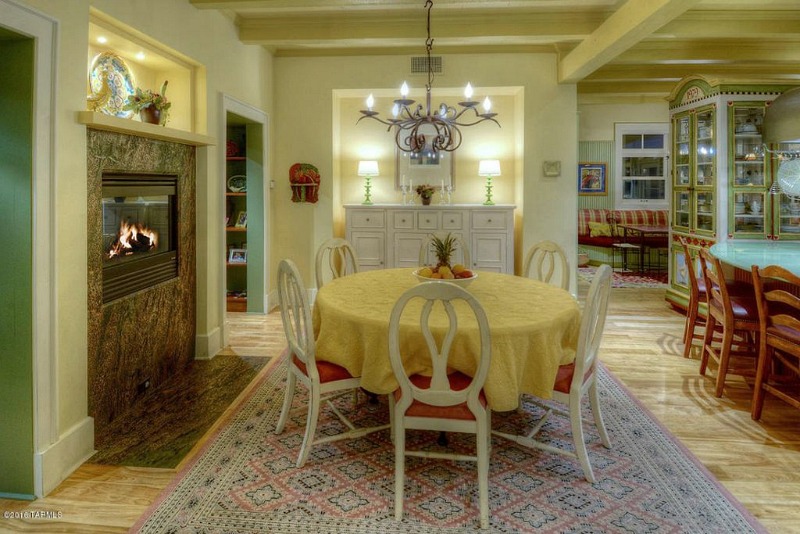 Round table with yellow tablecloth and chairs off kitchen