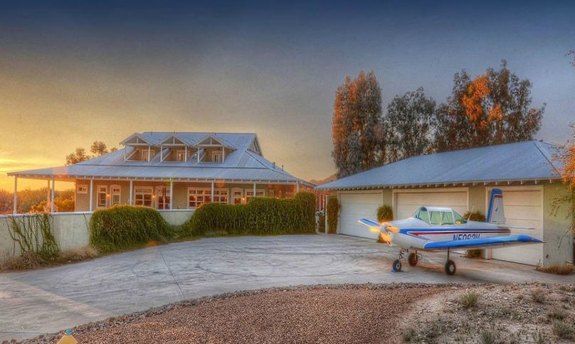 A small plane parked in front of a house