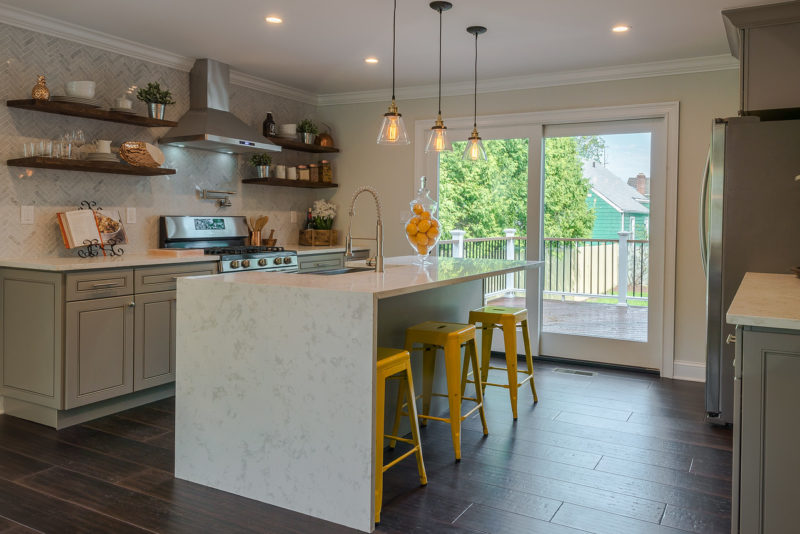 A kitchen with an island and yellow barstools