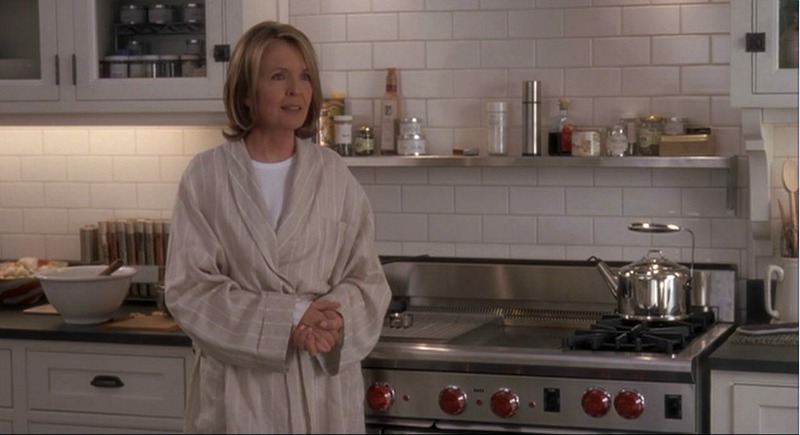 Diane Keaton standing beside oven range in the kitchen
