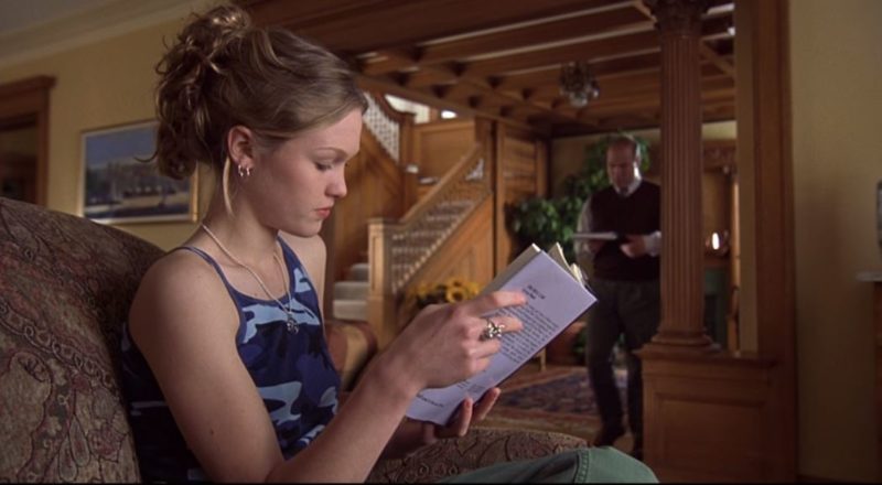 Julia Stiles lisant un livre dans le salon