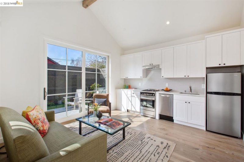 Kitchenette inside guest cottage with white cabinets