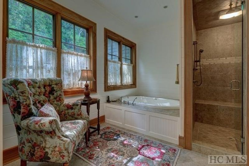 Bathroom with upholstered armchair and tub