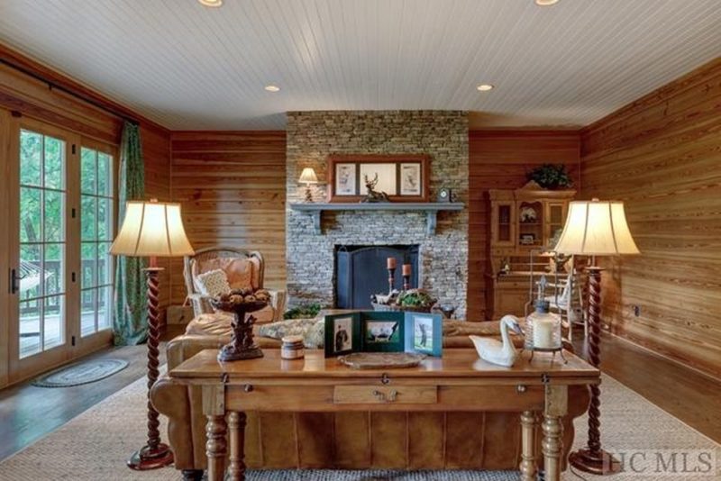 Lower level family room with wood plank walls and stone fireplace