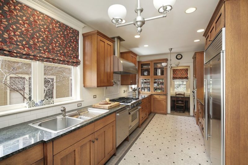 A large kitchen with stainless steel appliances and wooden cabinets