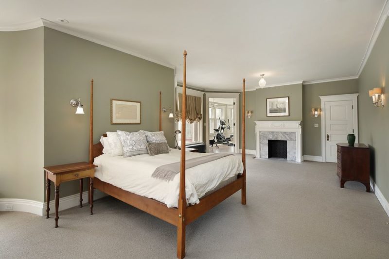 A bedroom with a four-poster bed and fireplace