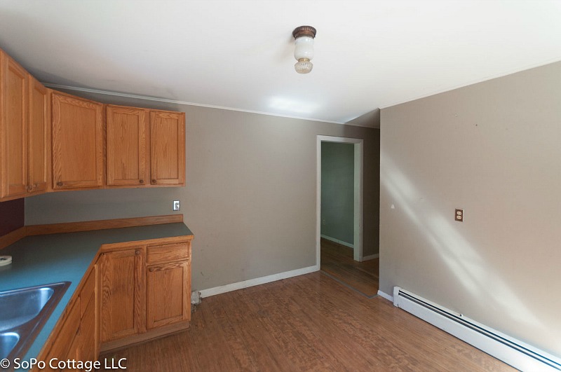 Empty kitchen before remodel with wood cabinets