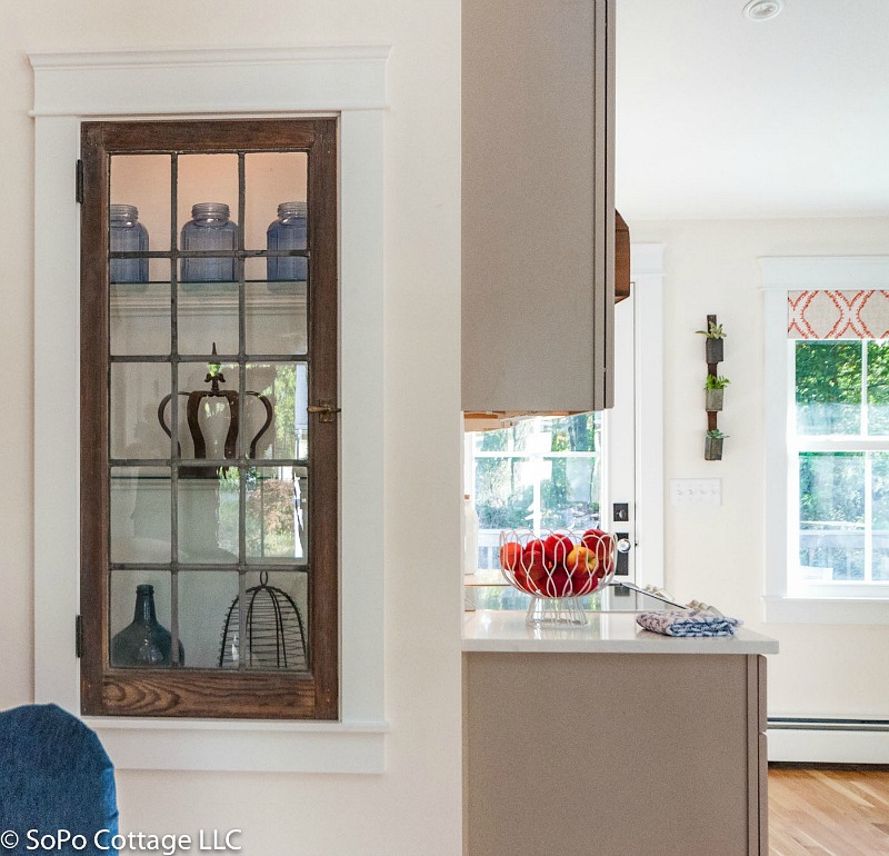 Closeup of built-in decorative shelves with old window used as glass door