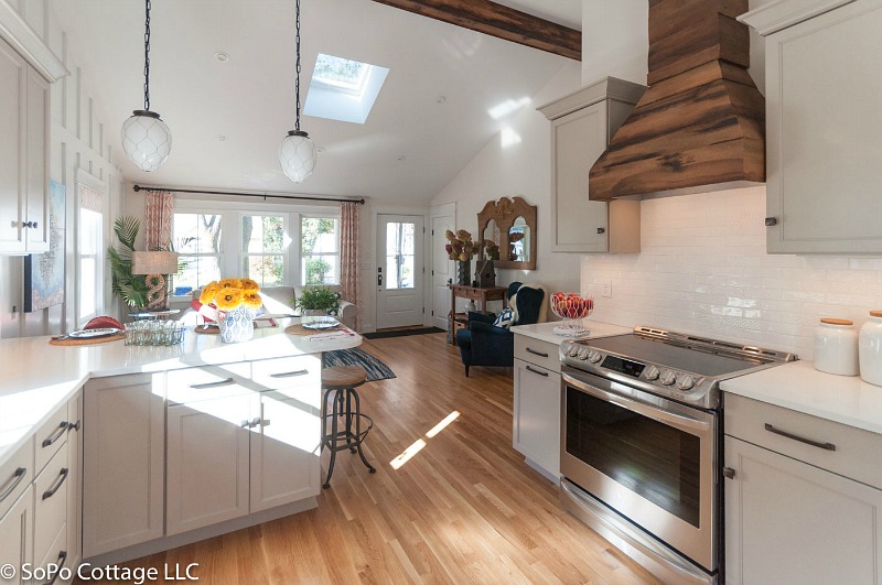 Cottage kitchen with stainless-steel range and wood hood