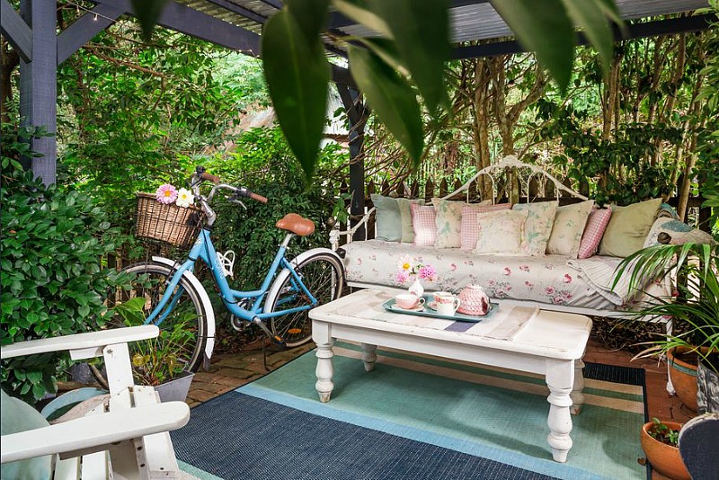 Blue bike with basket and settee in backyard