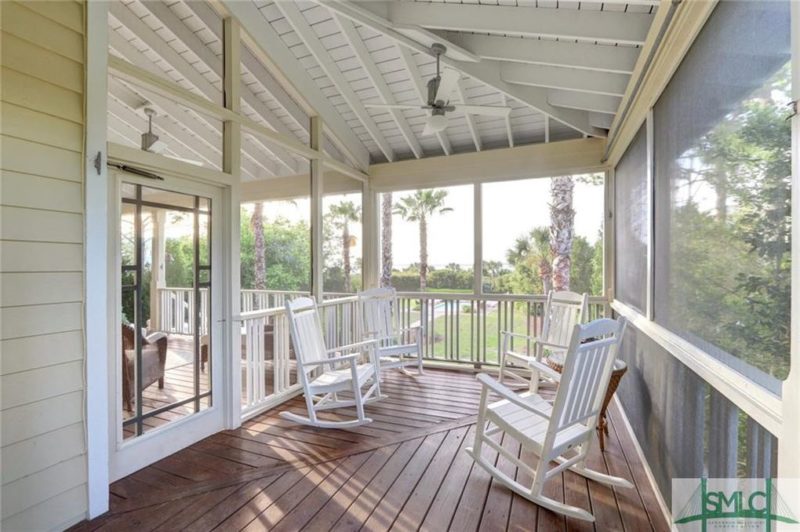 Screened porch with four white rocking chairs