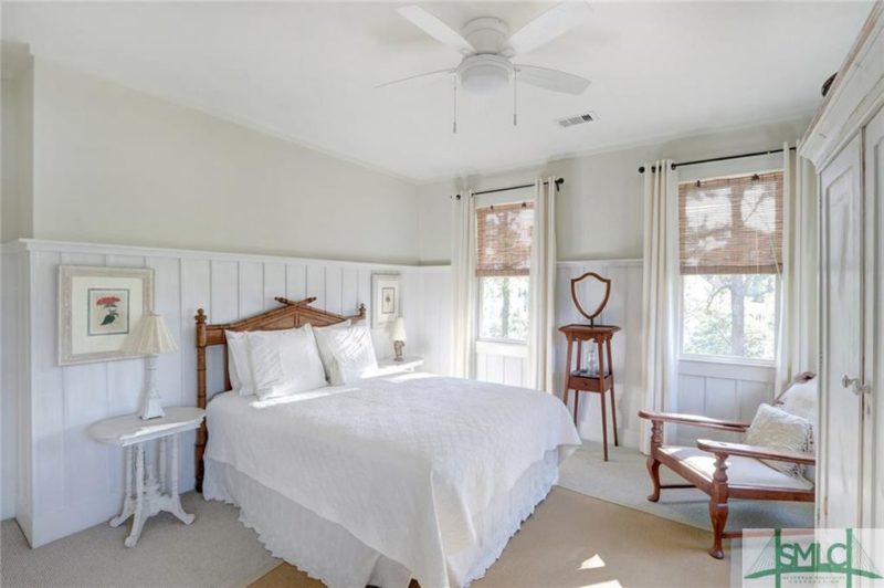 Bed with white quilt in guest room