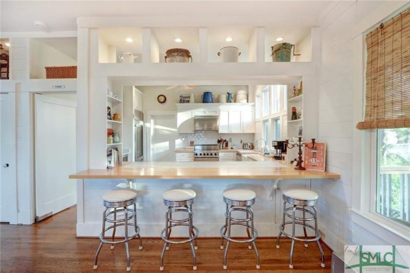 Window between kitchen and dining room with bar stools