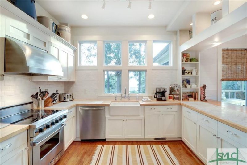 A kitchen with a stove a sink and a window