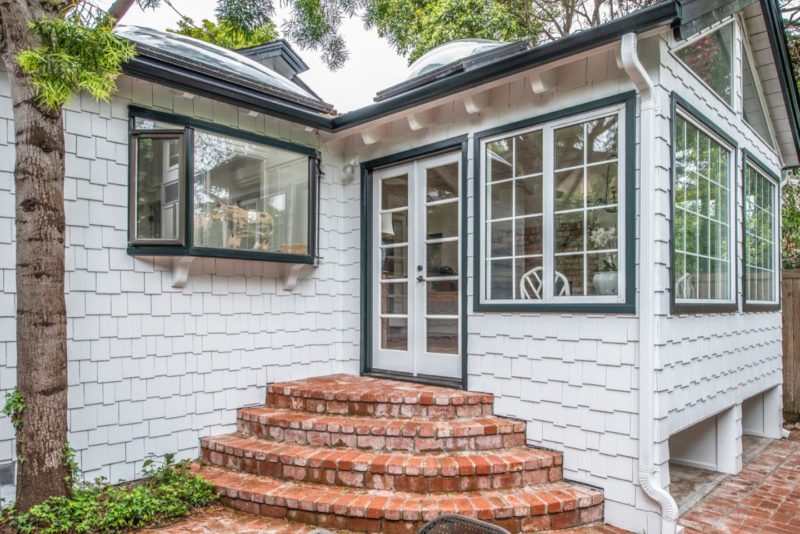 Exterior brick steps leading up to back door of cottage