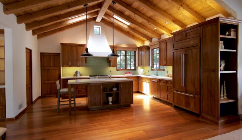 A kitchen with a hardwood floor and wood cabinets