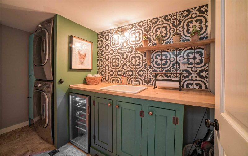 Laundry room with green cabinets, sink and wine fridge