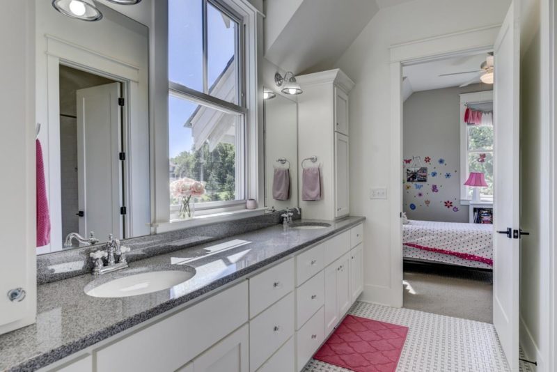 Bathroom with two sinks and white cabinets