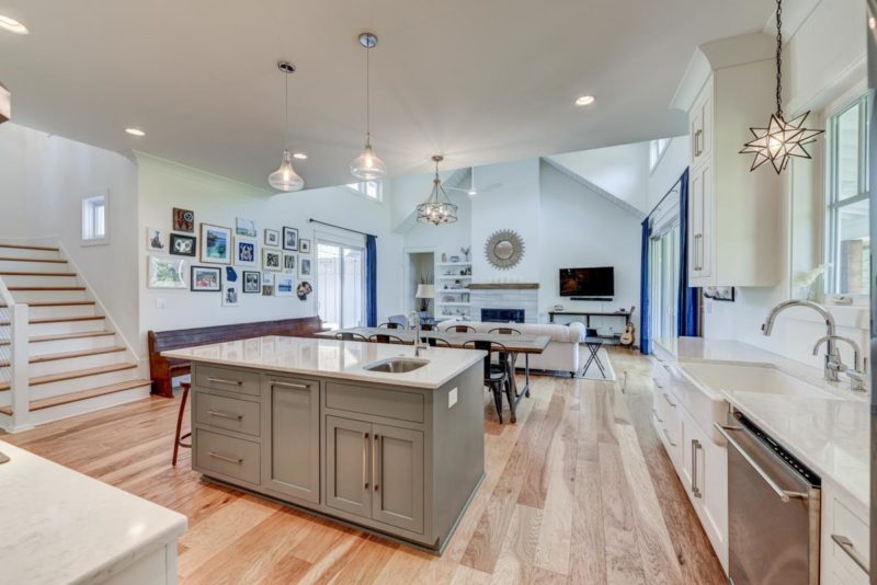 A kitchen with an island in the middle of a hard wood floor