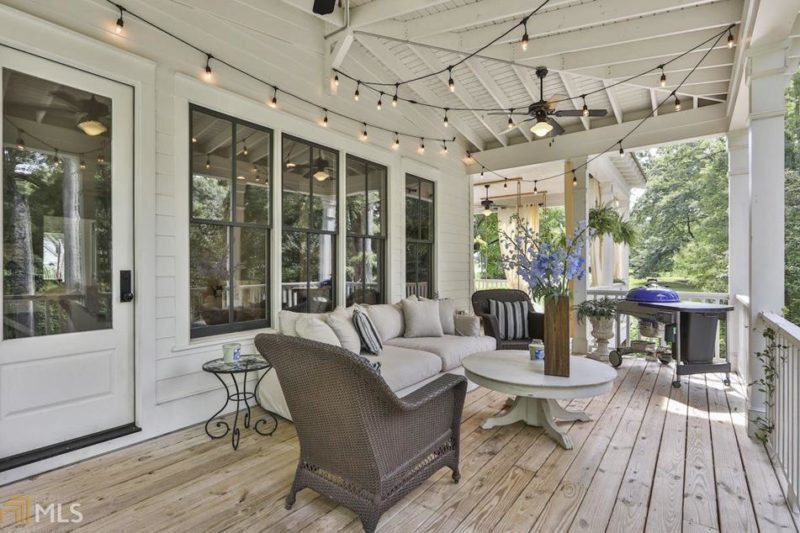 Back porch behind modern farmhouse with twinkle lights