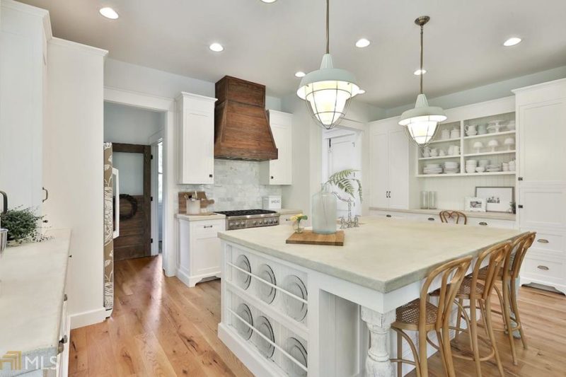 White farmhouse kitchen with large island and wood hood over range