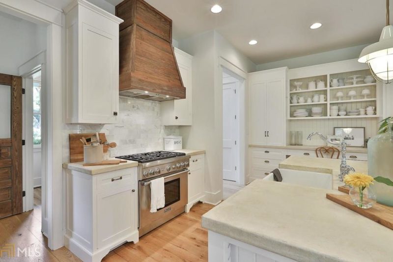 White kitchen with wood hood over range